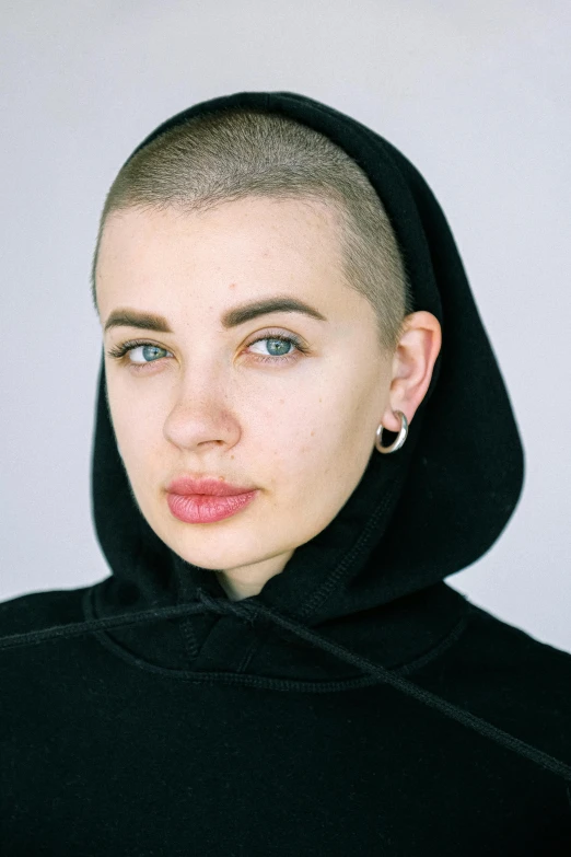 a woman with short hair wearing a hoodie