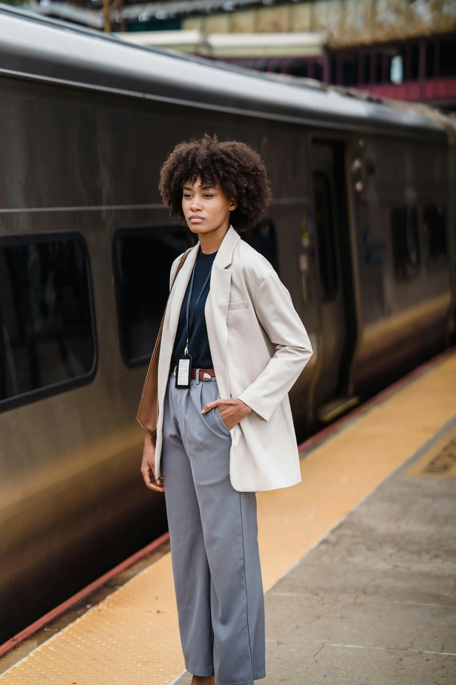 woman standing on train platform next to silver train