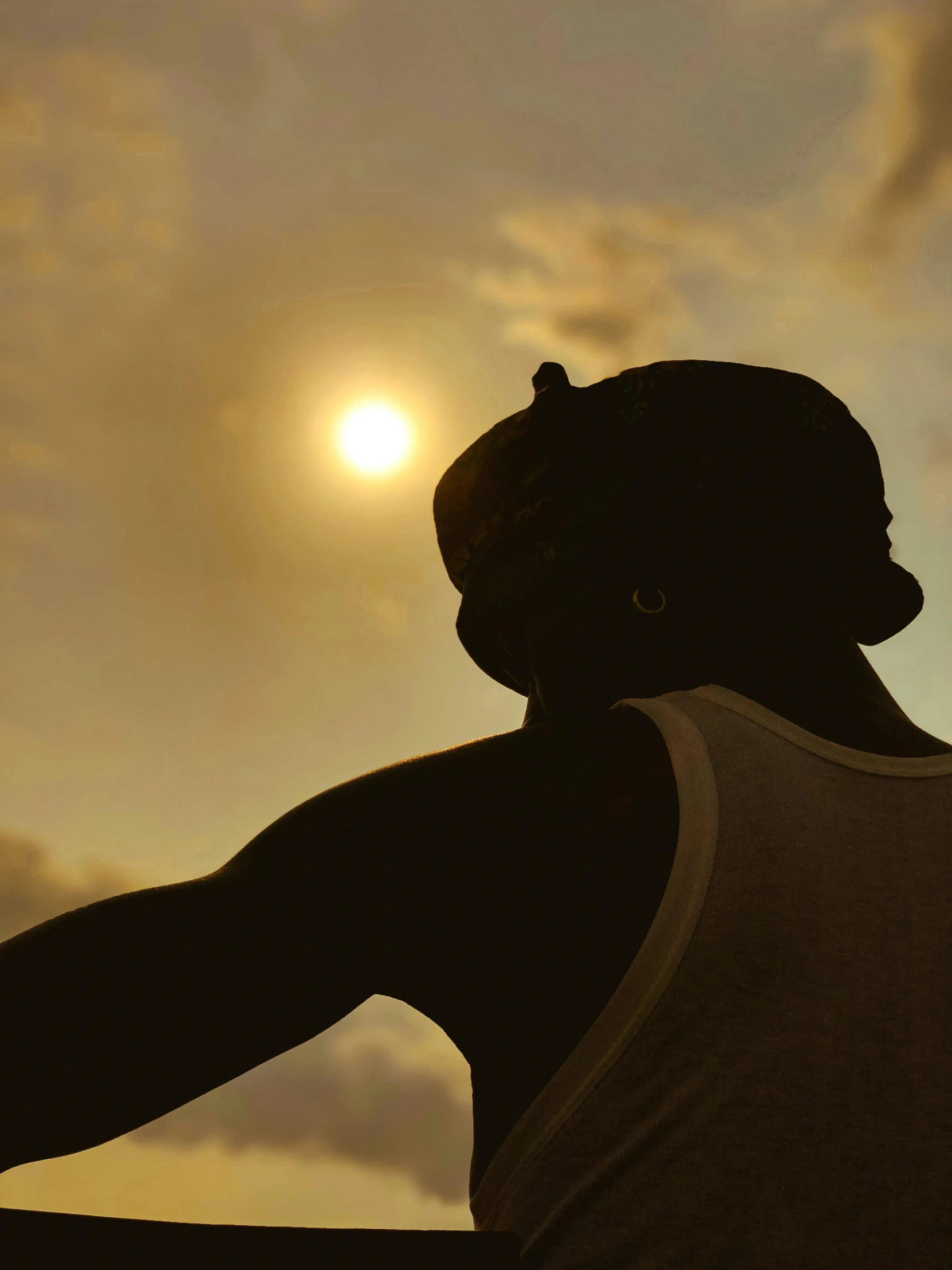 silhouette of a woman's back with the sun in the background