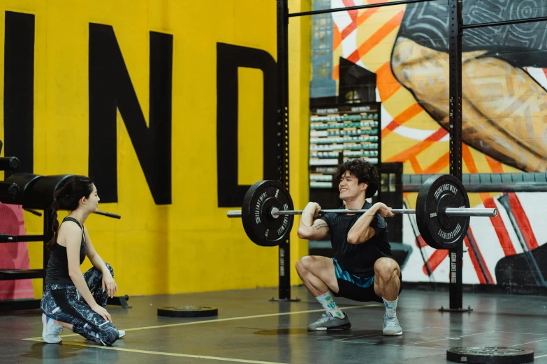 there are two men doing squat exercises in the gym