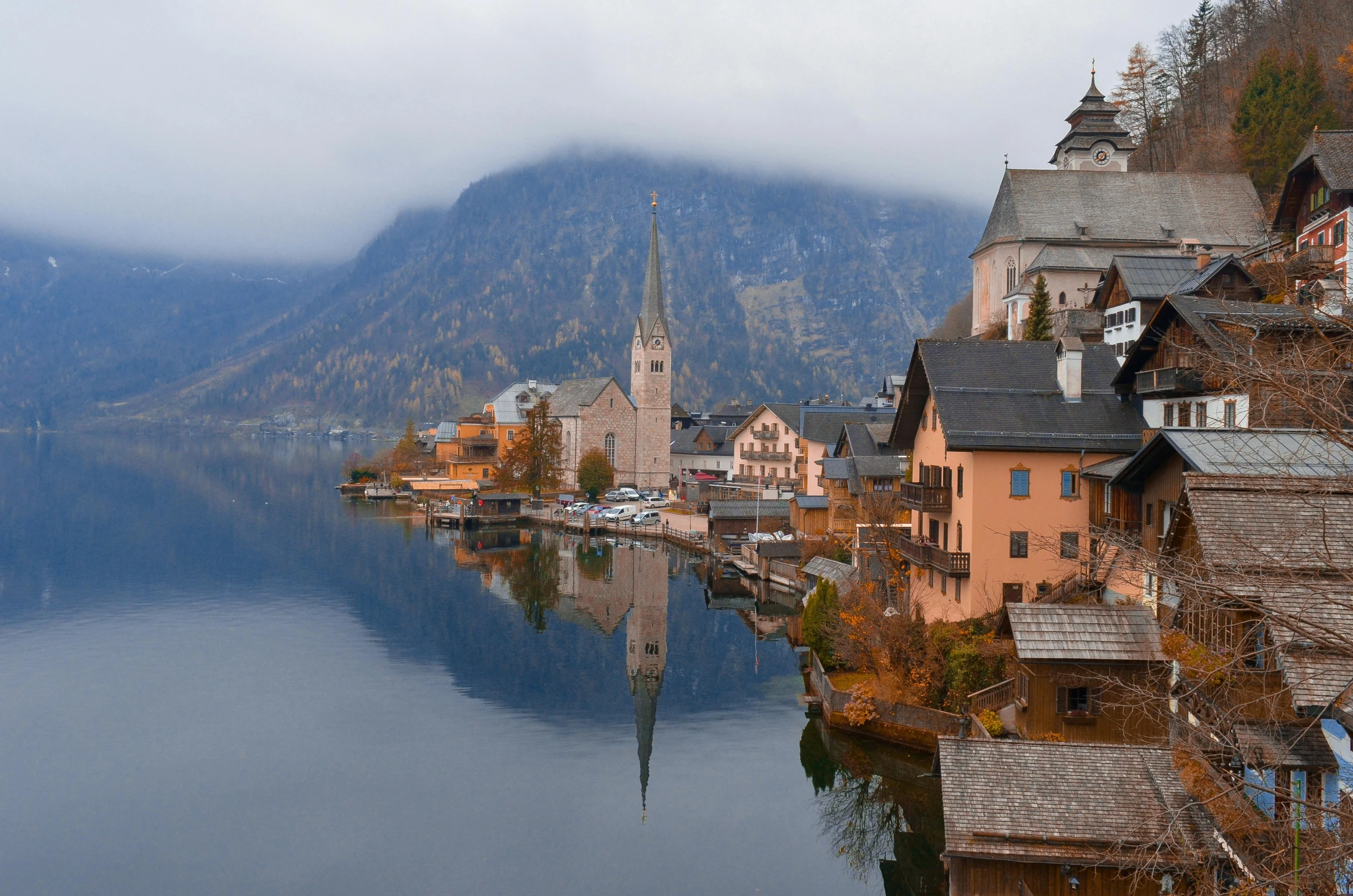 the town has mountains, houses and water with a steep hill behind it