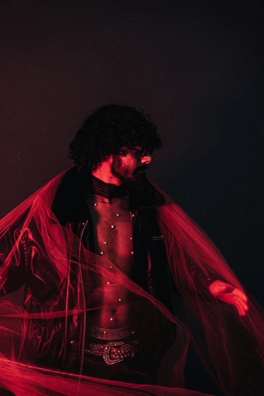 a man dressed up in costume standing under red light