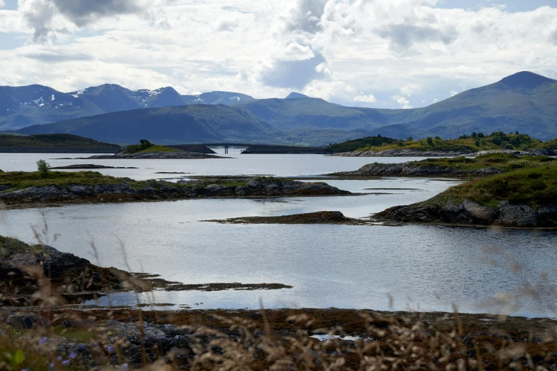 a person in water paddling down with mountains in background