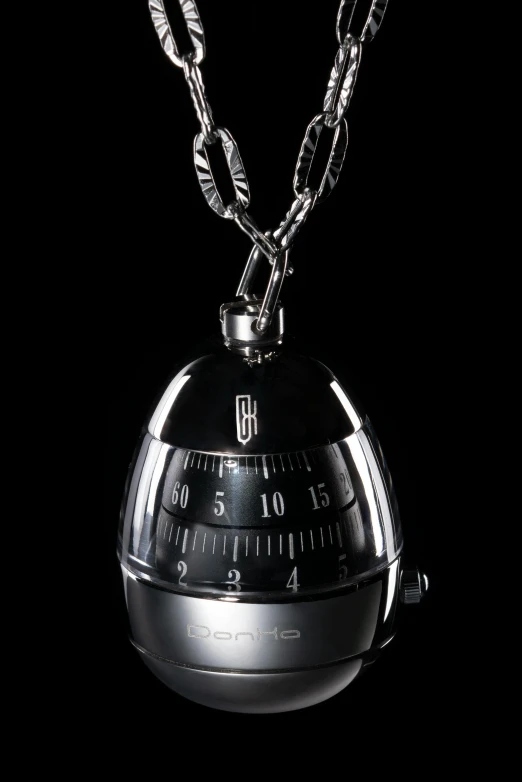 the black object with a chain on it is attached to a pendant