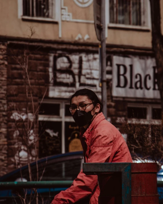 the man is wearing a red jacket and black sunglasses