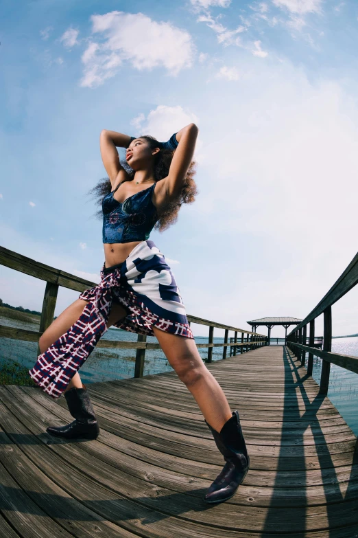 a woman with a cowboy hat is dancing on the dock