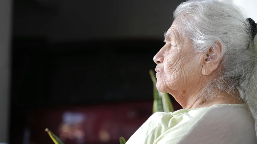 an old woman wearing a white dress and smiling