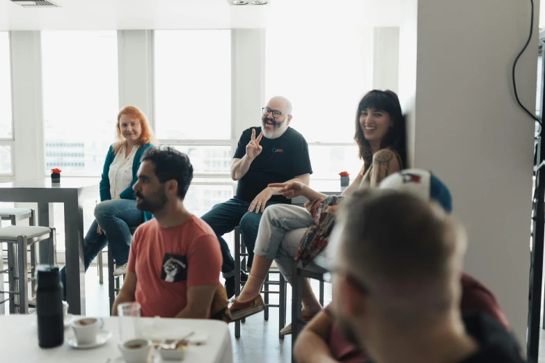 several people are sitting around having coffee and tea