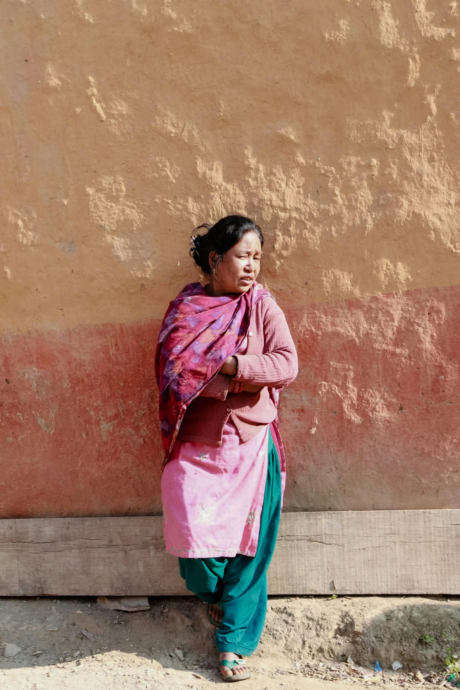 a woman is standing next to the wall