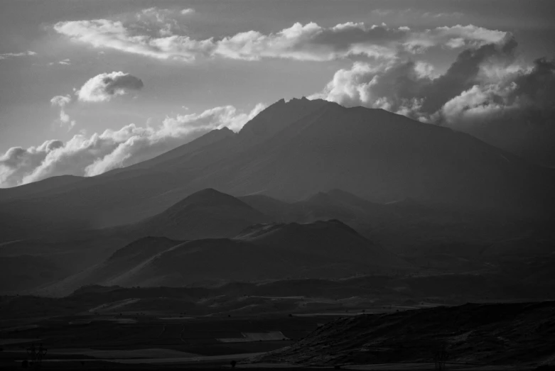 a mountain top with clouds in the sky