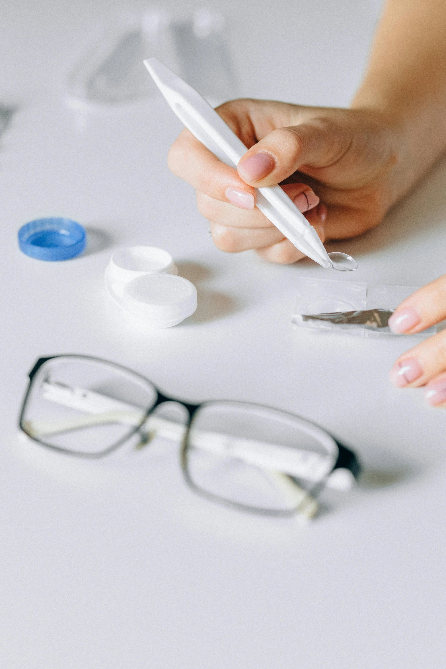 two women working together with a phone and various glasses on the table