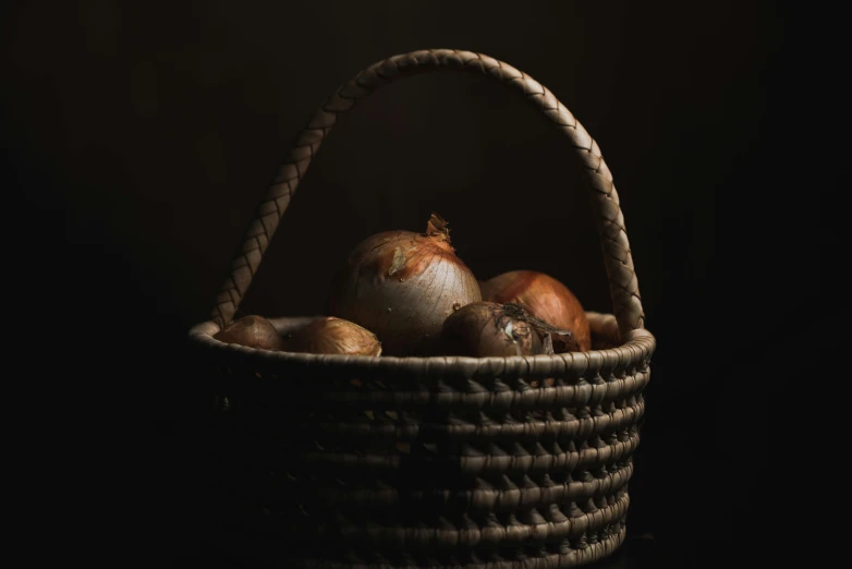 basket with onions in it on a black table