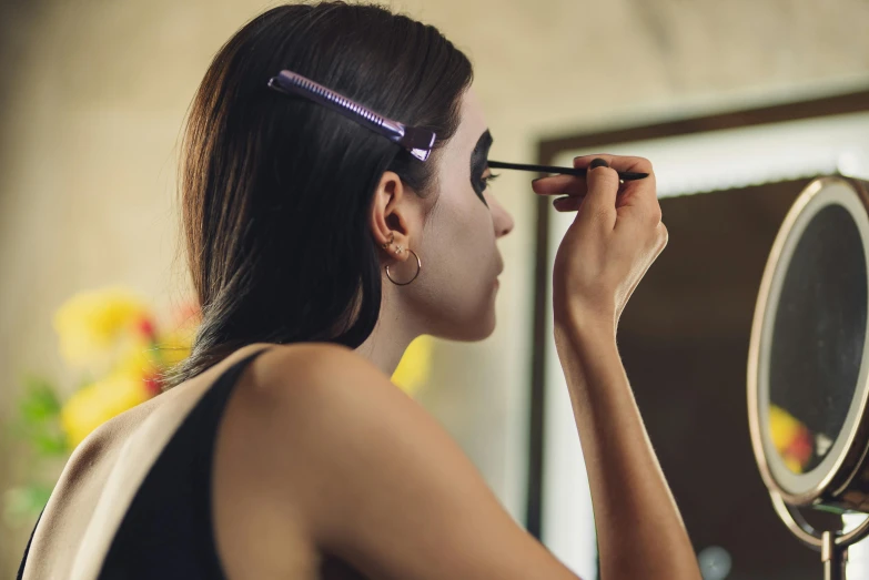 a woman with purple mascara is putting on her make up