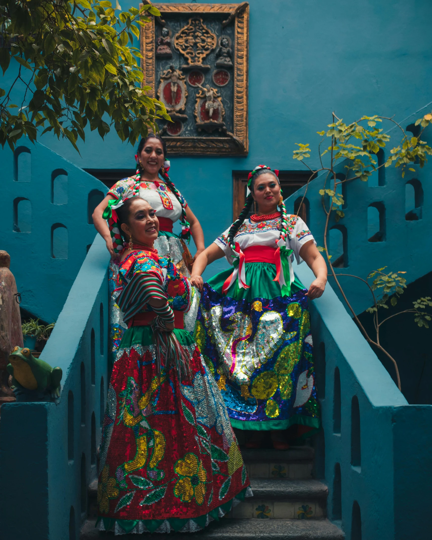 four women in colorful costumes walk down the stairs