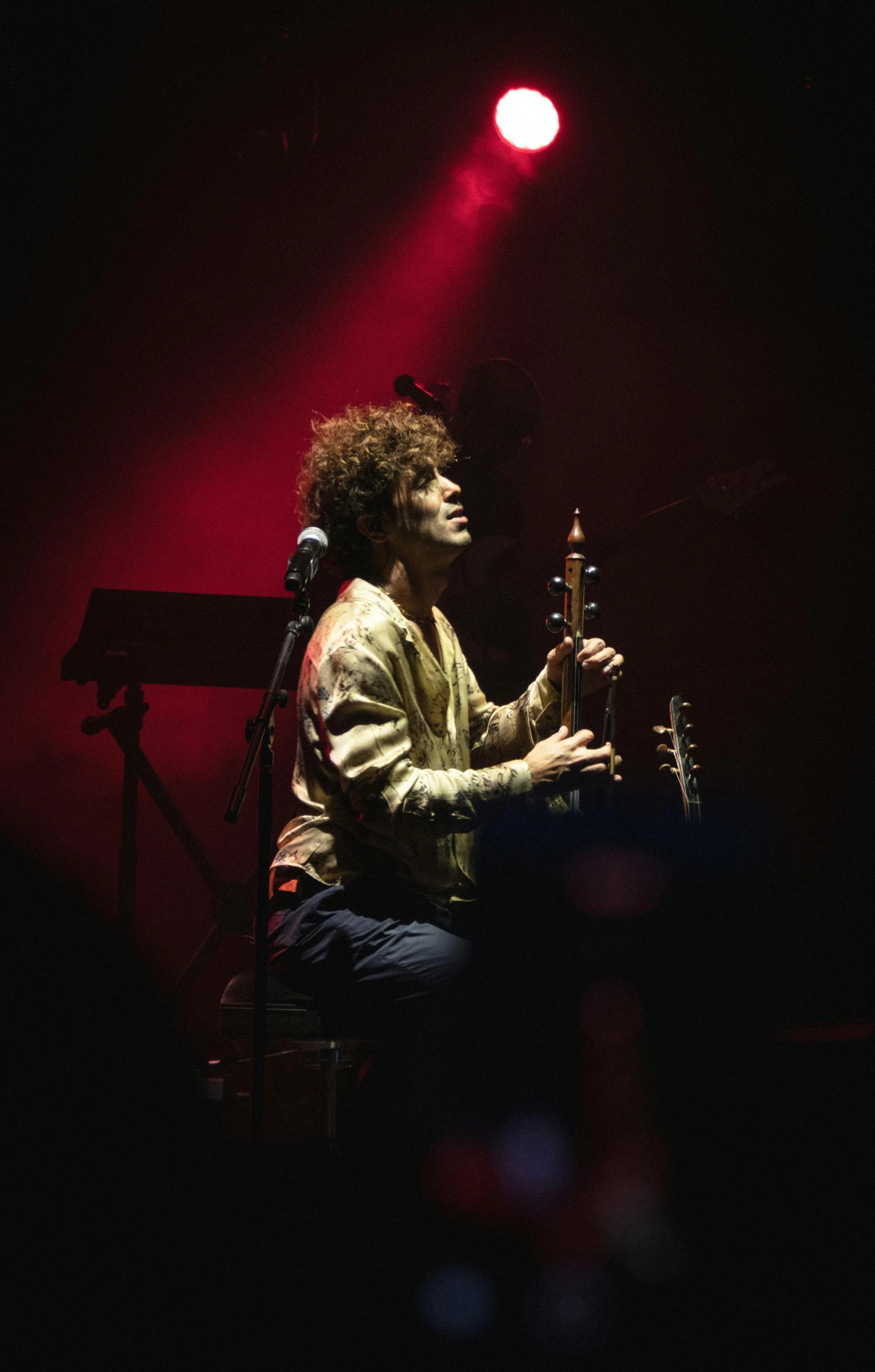 a man playing the sitar in front of a microphone