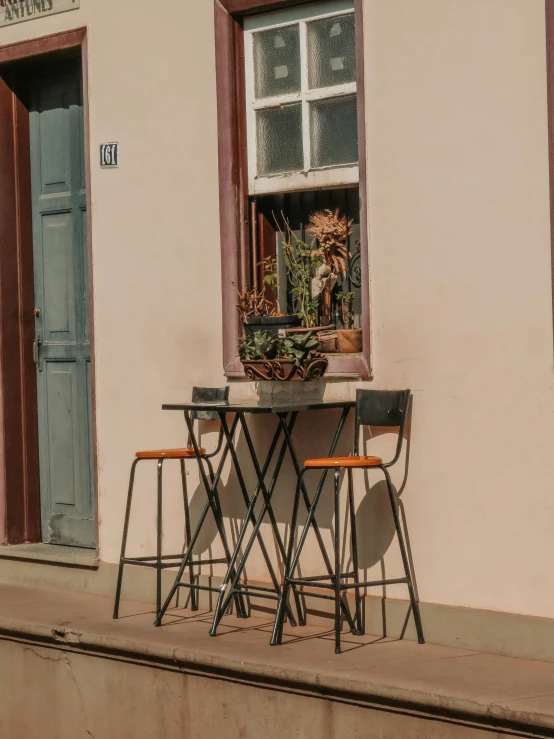 a table and chairs are sitting outside of a house