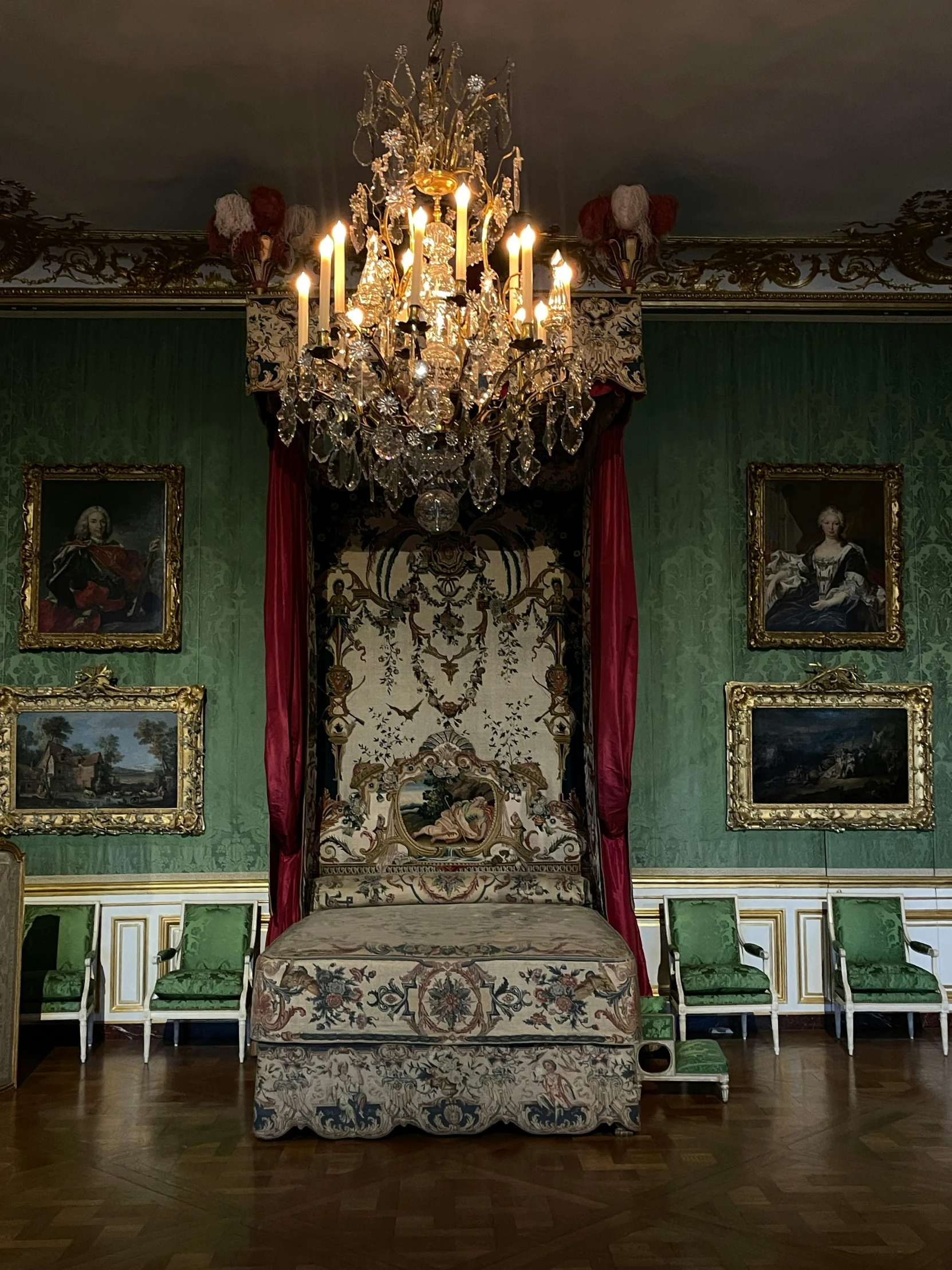 a fancy chandelier in a room with some paintings