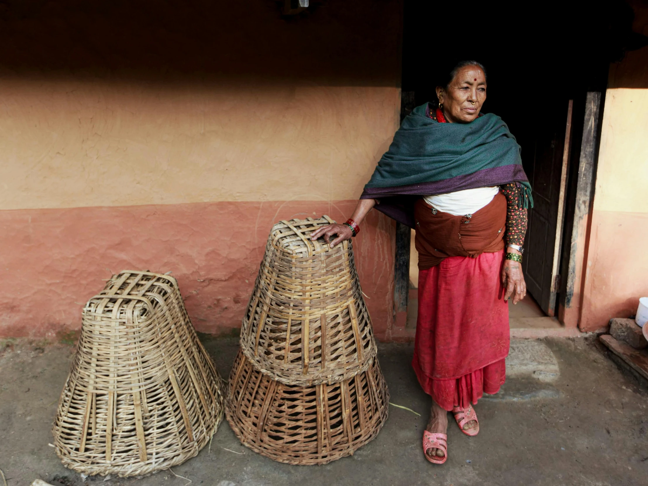 an old woman is looking through two pieces of rattan