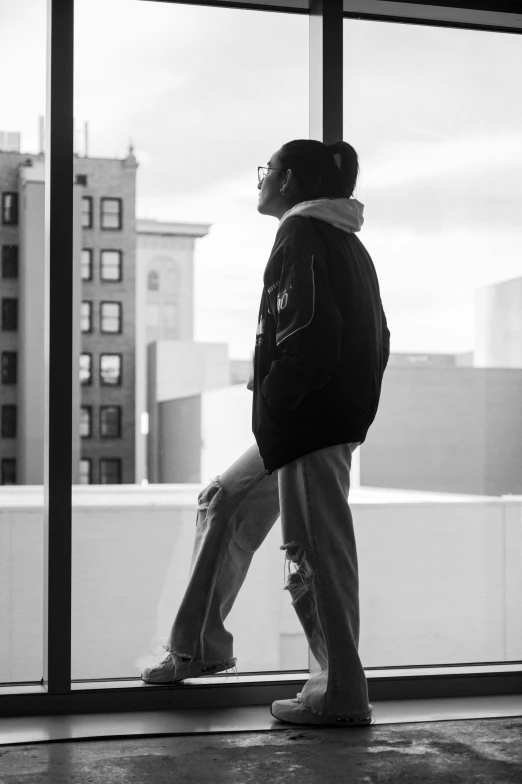 a boy walks by a window in a building