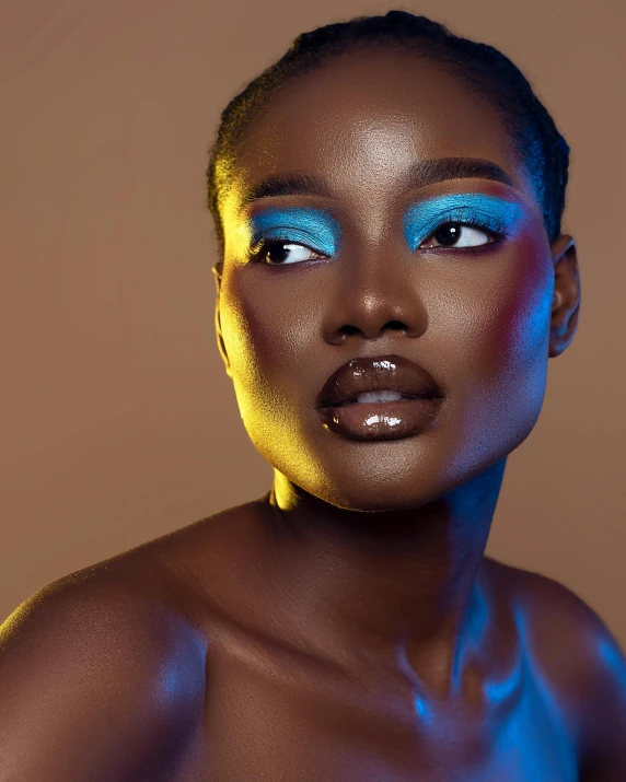 a woman wearing bright blue make up and gold lipstick