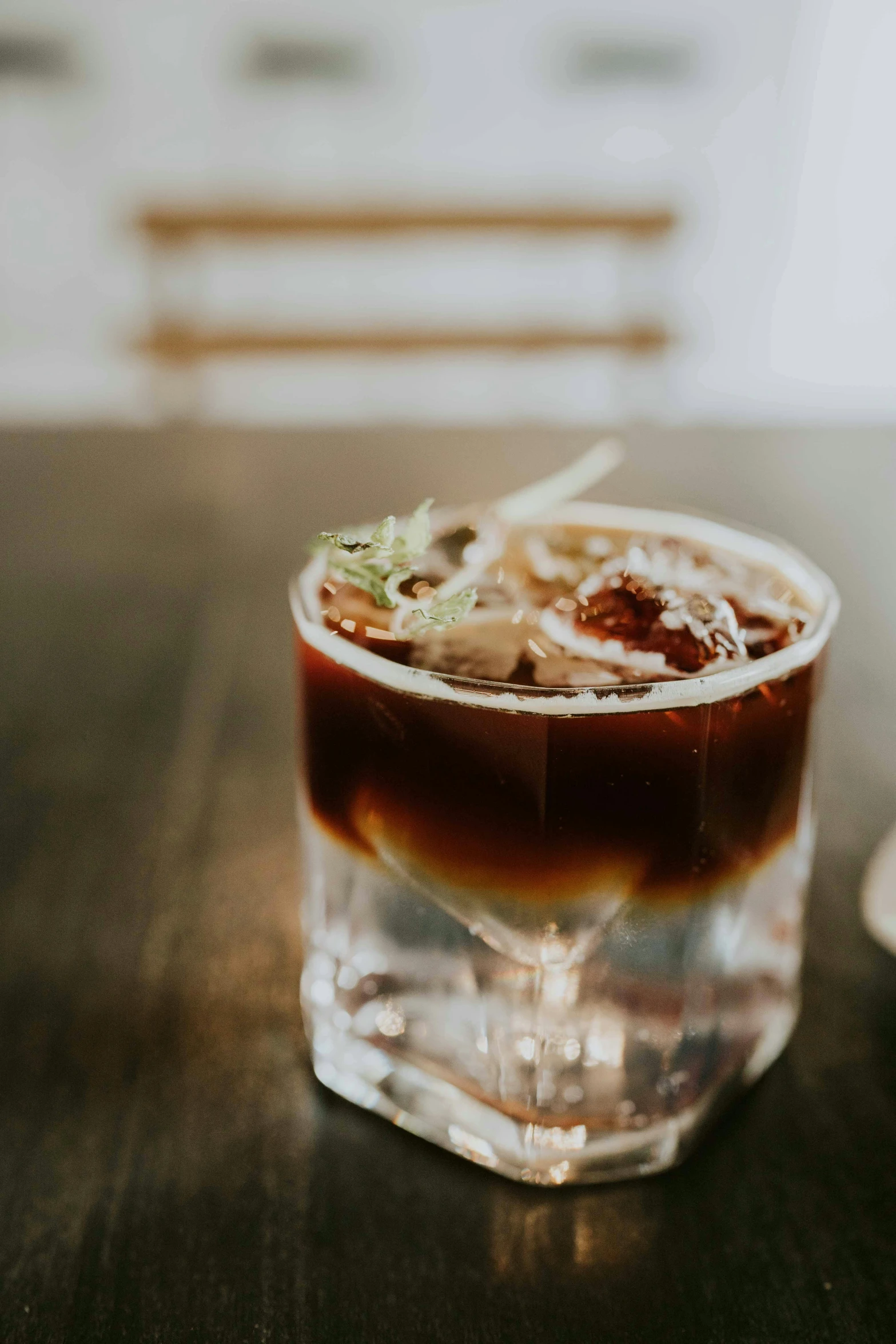 a drink in a clear glass sits on a table