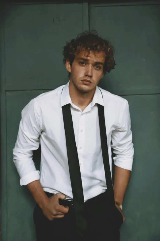 a young man in suspenders and a shirt is posing