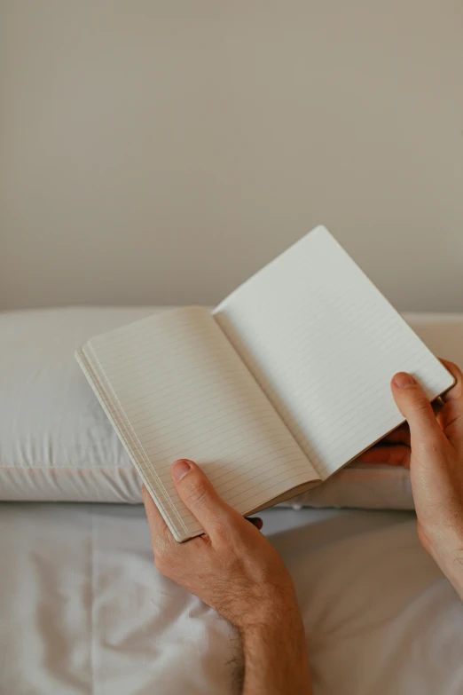 a man sitting in bed while reading a book