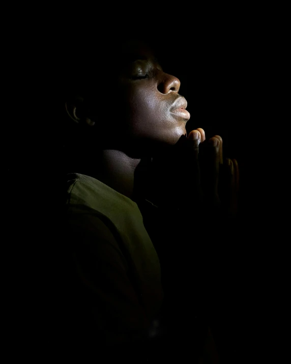 woman standing in the dark while she's holding a banana