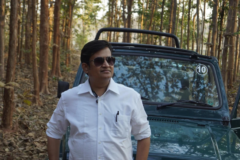 a man in white shirt next to green jeep