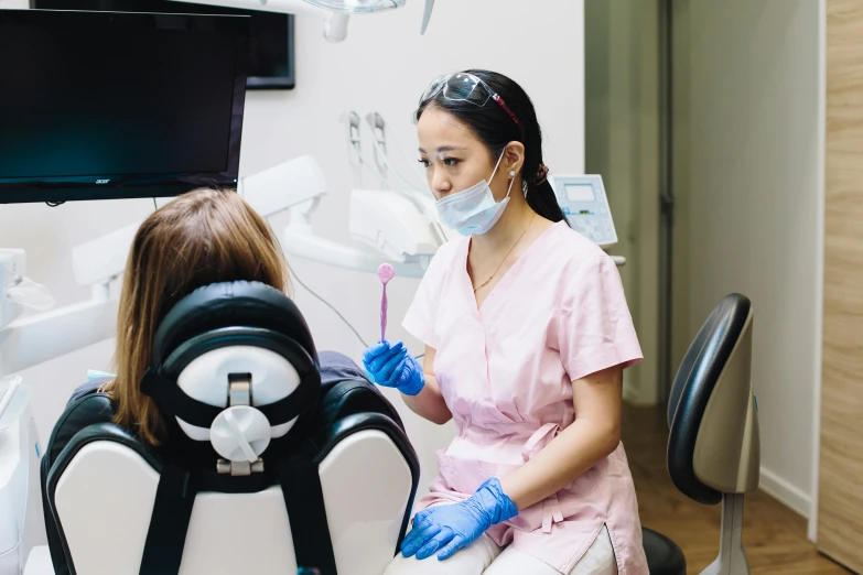 the dentist is watching two women in their chair