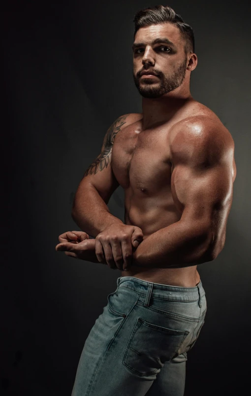 a man in jeans, shirtless, showing his muscle