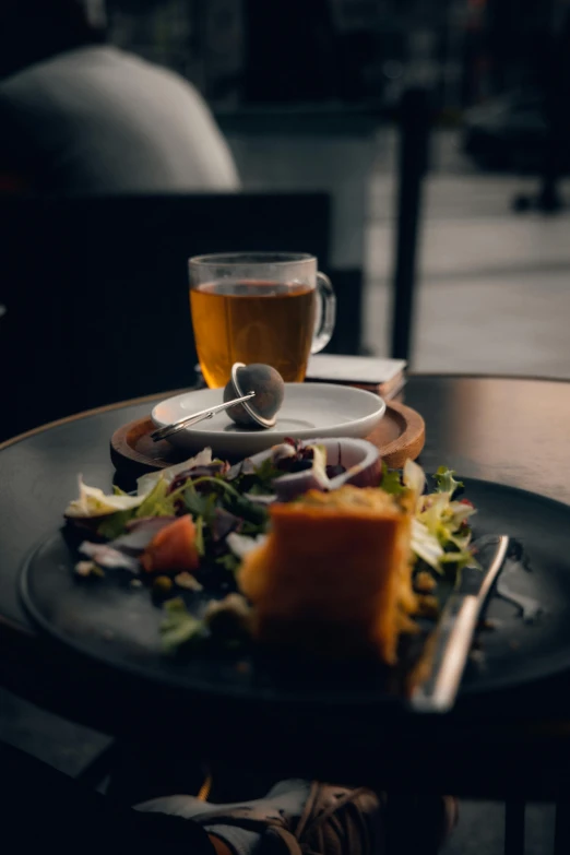 a plate with a salad and two forks and a cup on the table