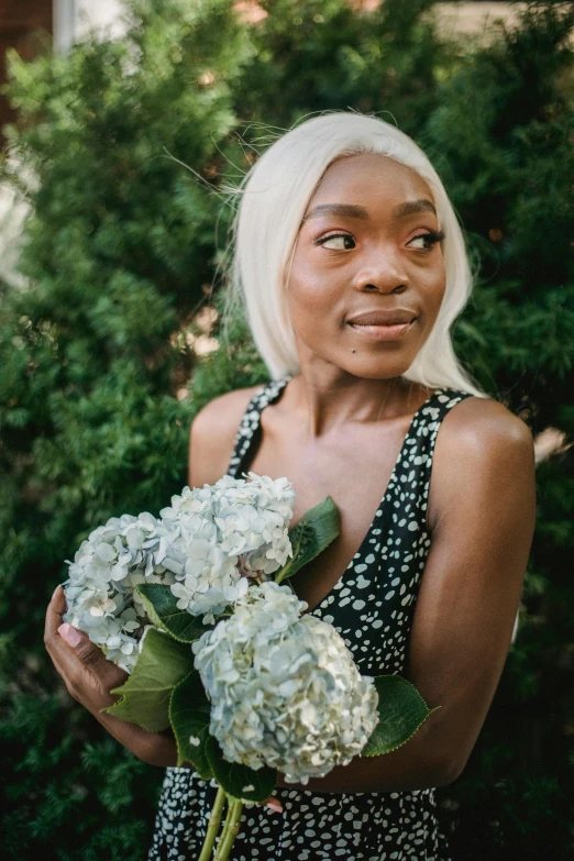 there is a woman standing outside with a bouquet in her hand