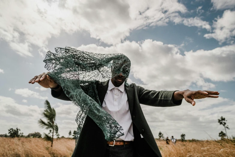 a man standing on top of a field holding a net