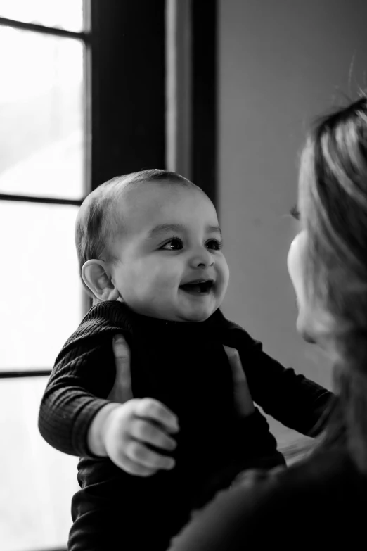 an older woman with a smiling baby in her arms