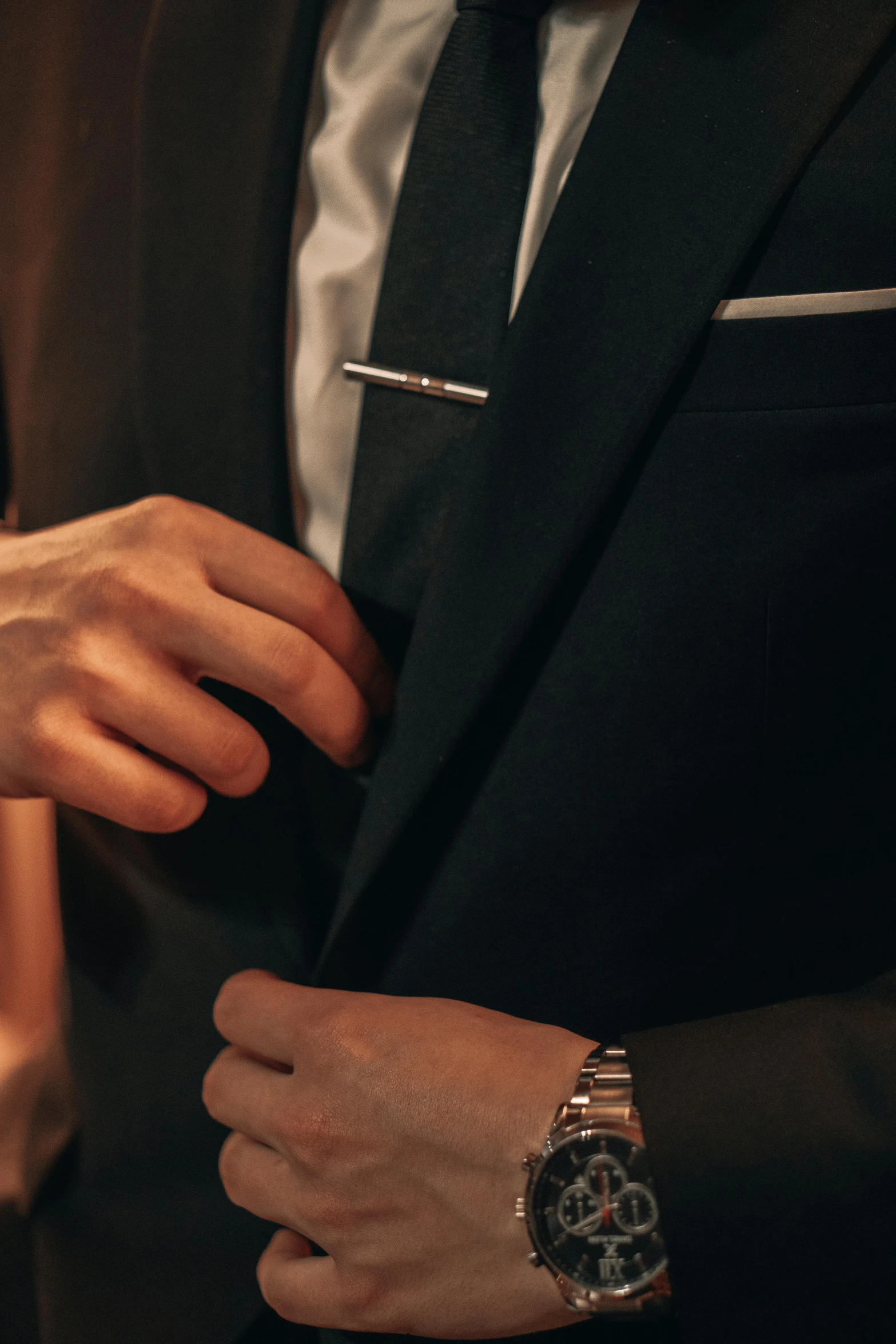 a close up of a person wearing a suit and watch