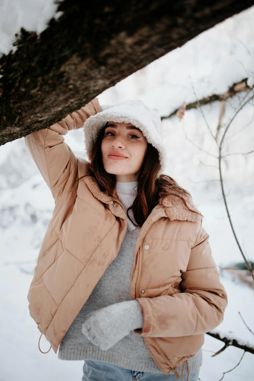 a woman in the snow holding onto a tree