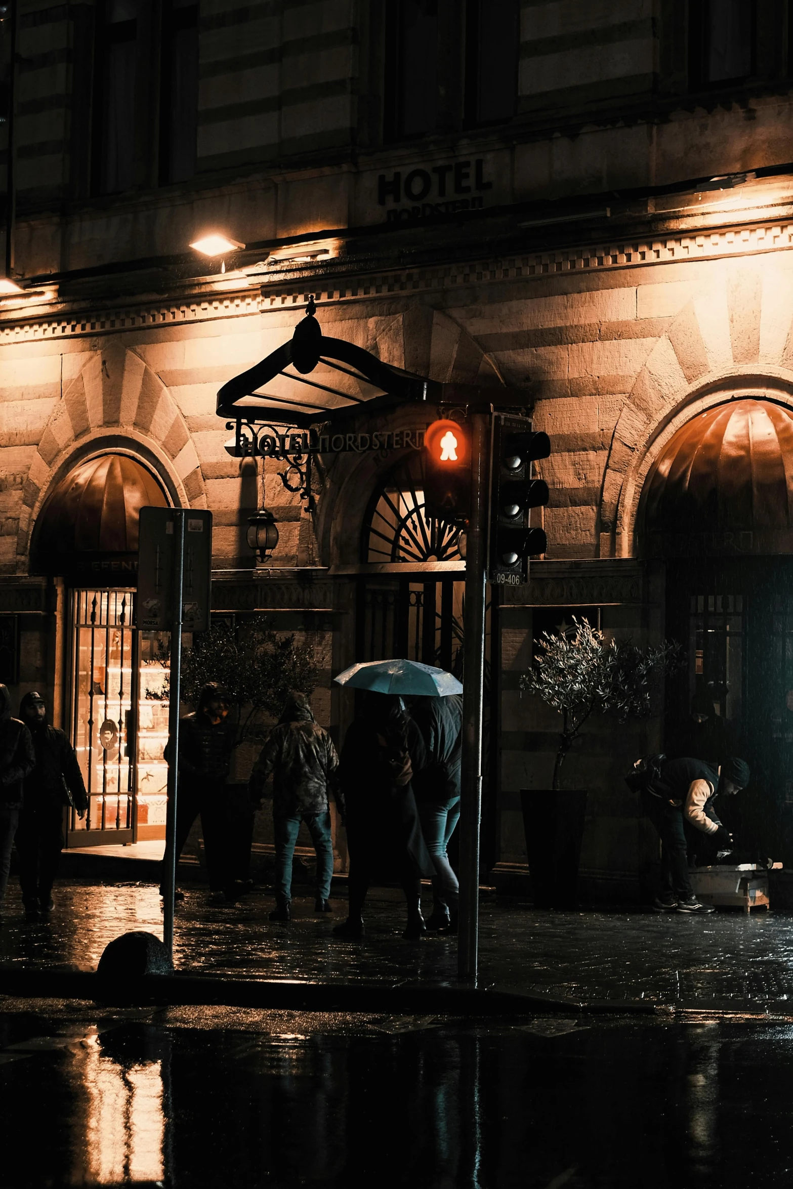 a group of people under an umbrella in the rain