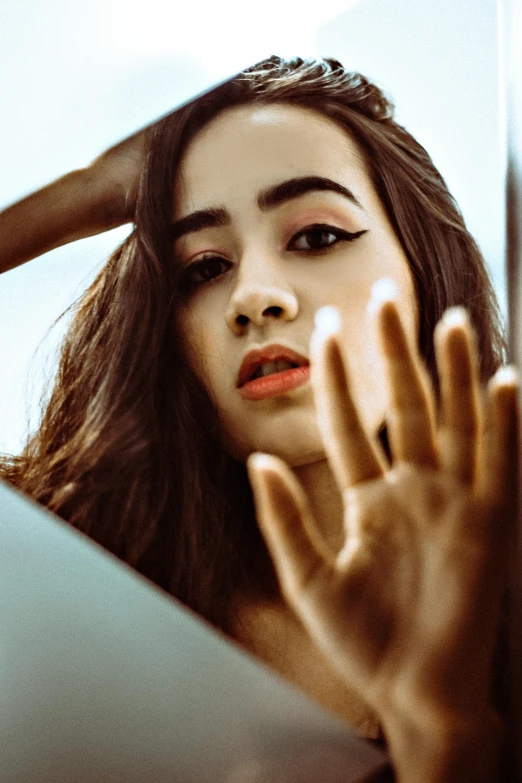 a close up of a person with her hands near her face