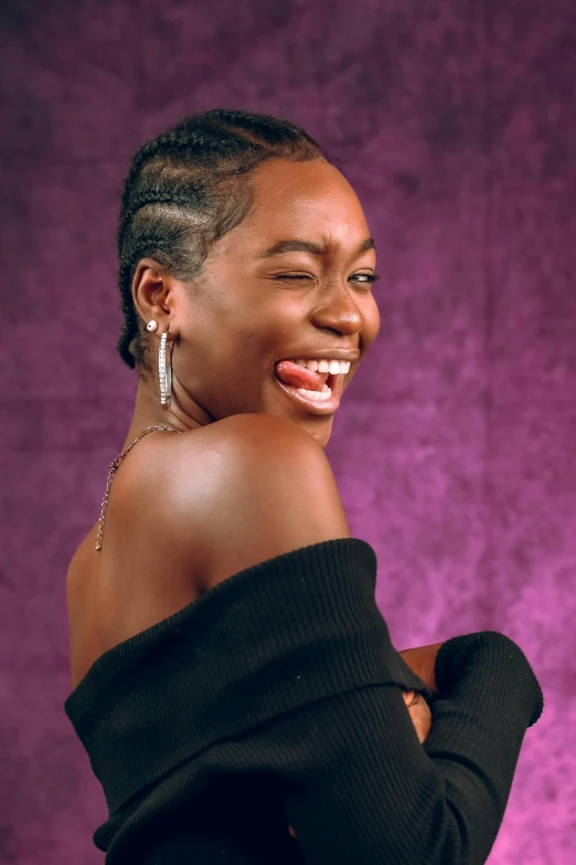 a woman wearing black smiling with purple backdrop