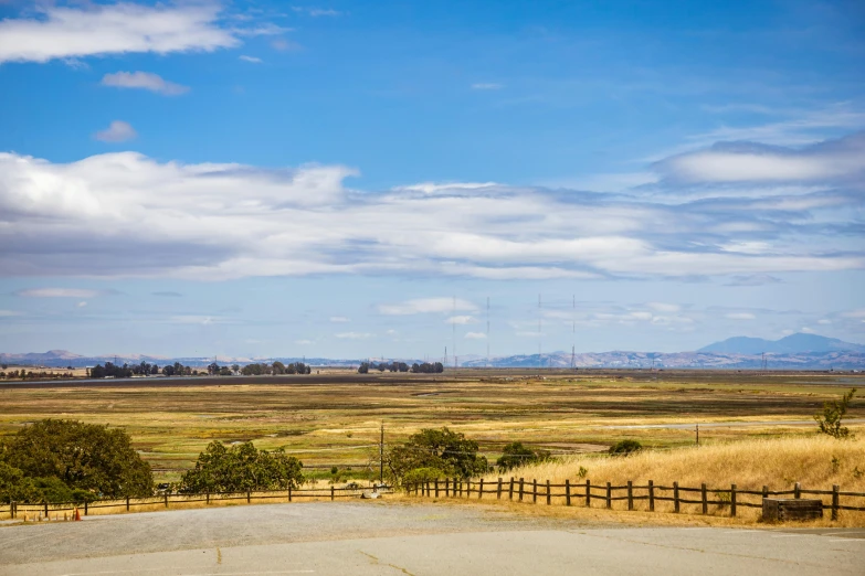 an open air parking lot next to a grassy field