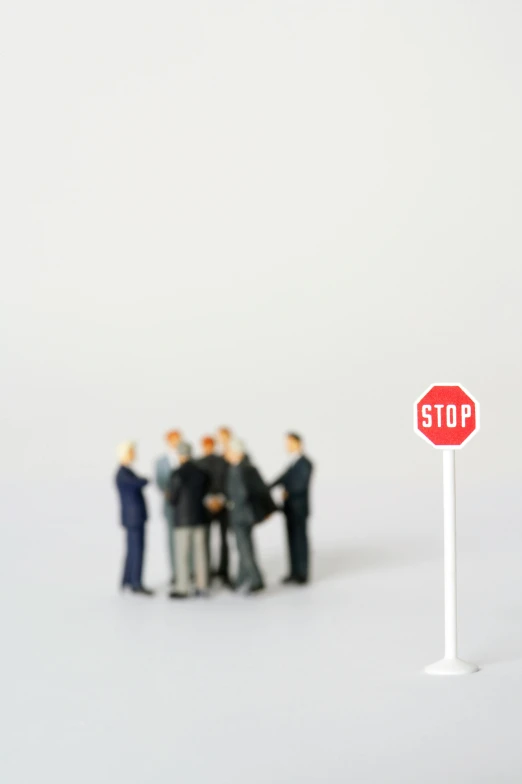 a group of people standing next to a stop sign