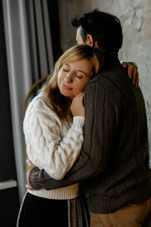 a young man holding a woman that is leaning his neck