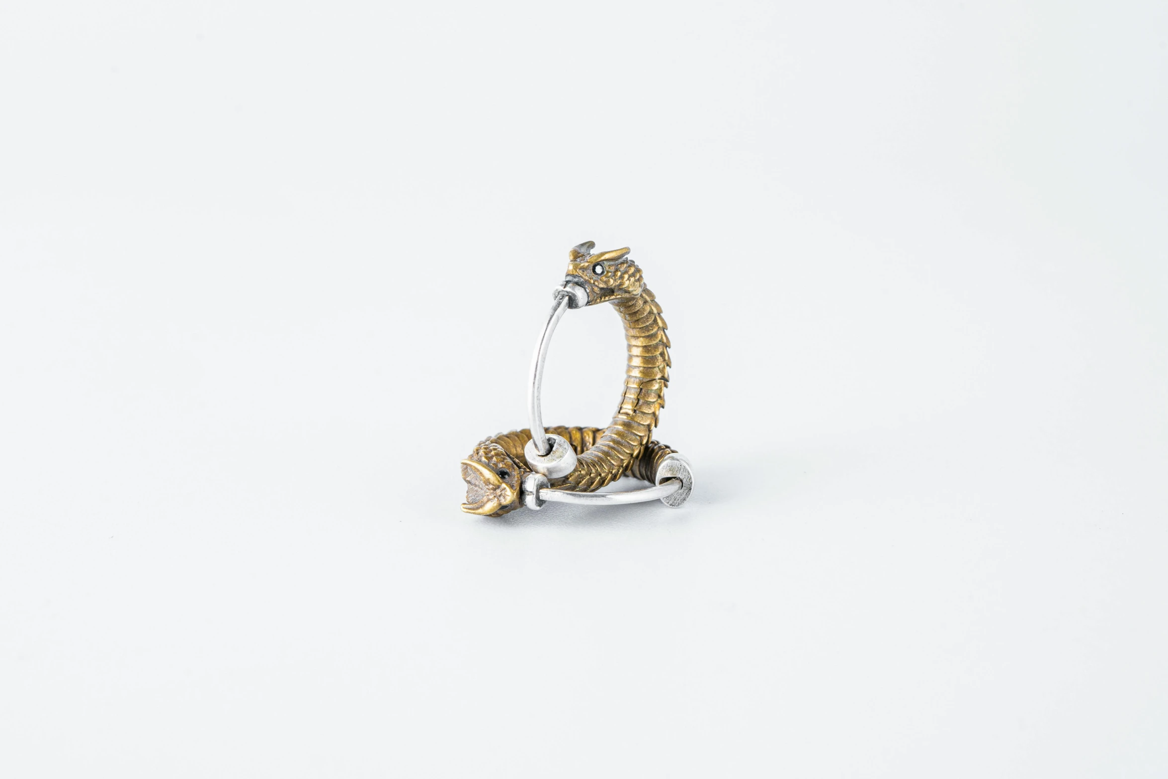 a yellow gold snake ring with a white topaz