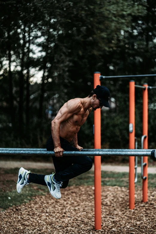 shirtless man riding parallel bar in outdoor park