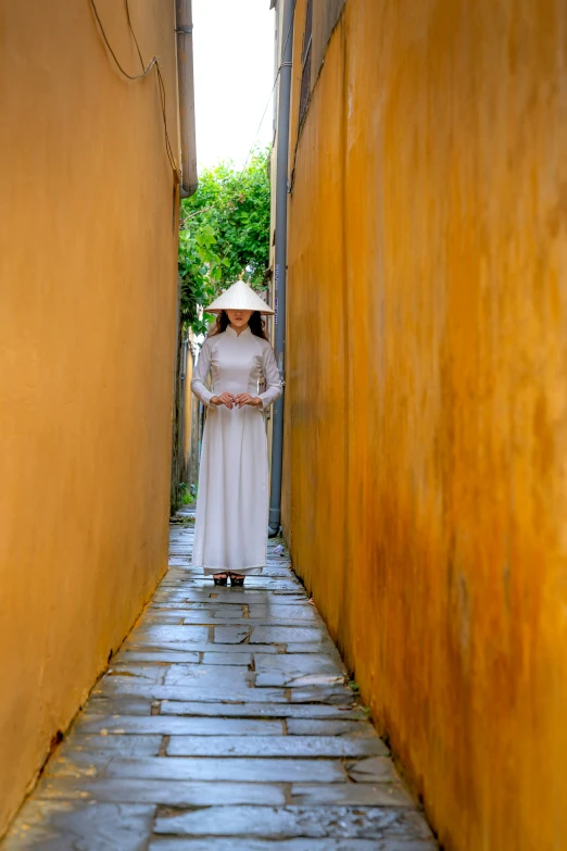 a woman wearing a long white dress and holding an umbrella