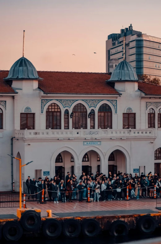 a group of people stand outside a large building