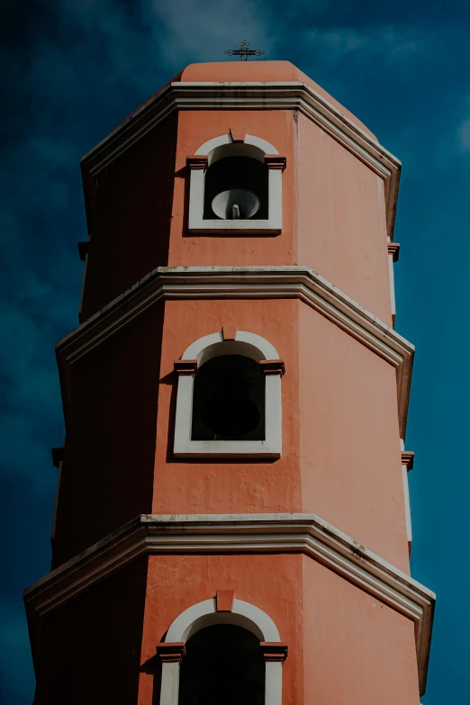 a red and tan tower with a clock at the top