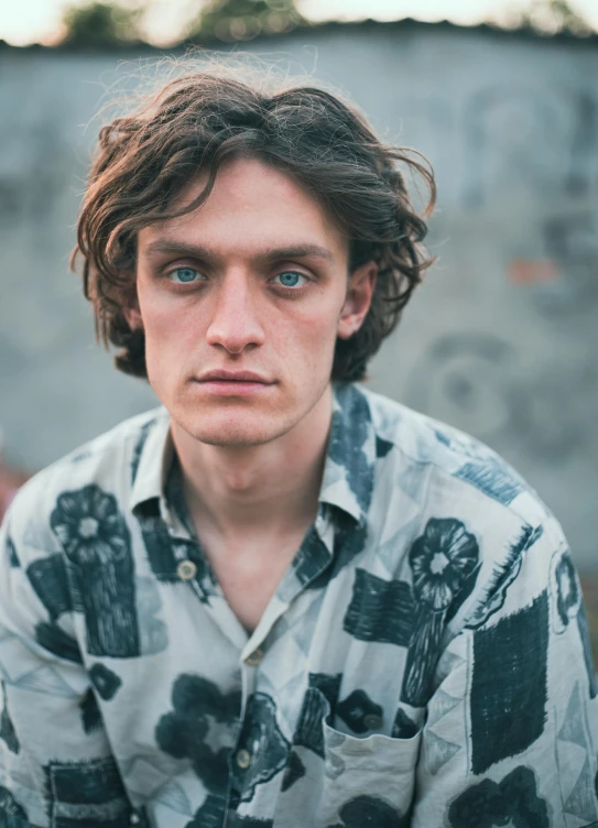 a man in a shirt sits against a wall