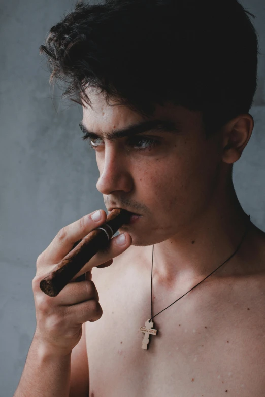 a shirtless young man with his hand on his mouth